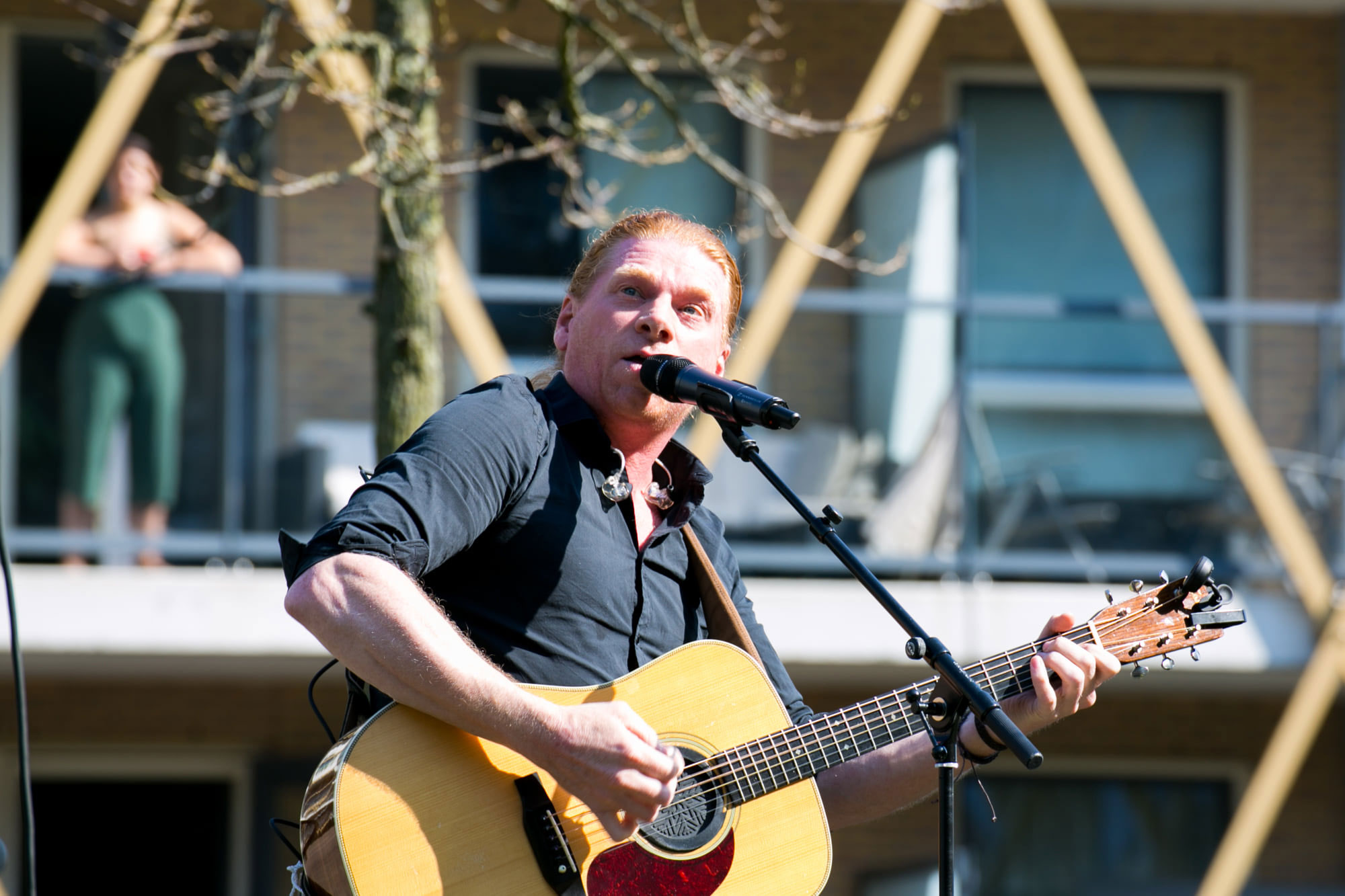 Akoestische-zanger-gitarist speelt buiten voor publiek muziek